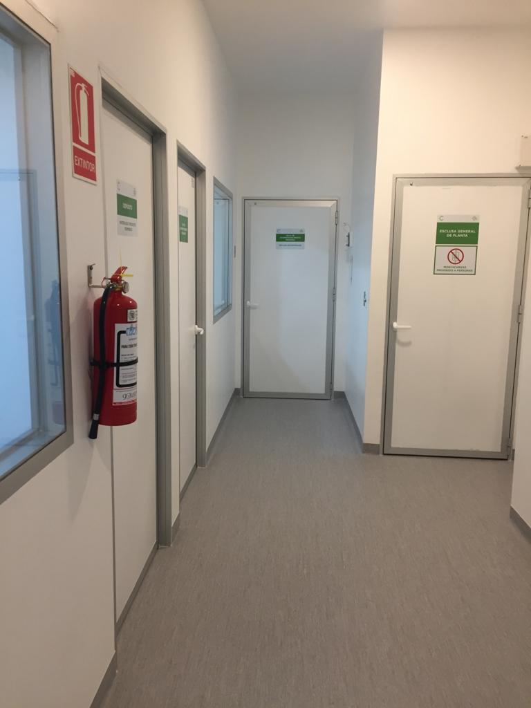 En la fotografía se observan cuatro puertas con contramarco de aluminio, piso de moquete y un bomberito.